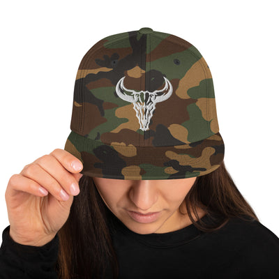 Gorra Snapback verde camuflaje con el logo de cráneo de toro blanco bordado de David Mateo Art. Moda urbana.