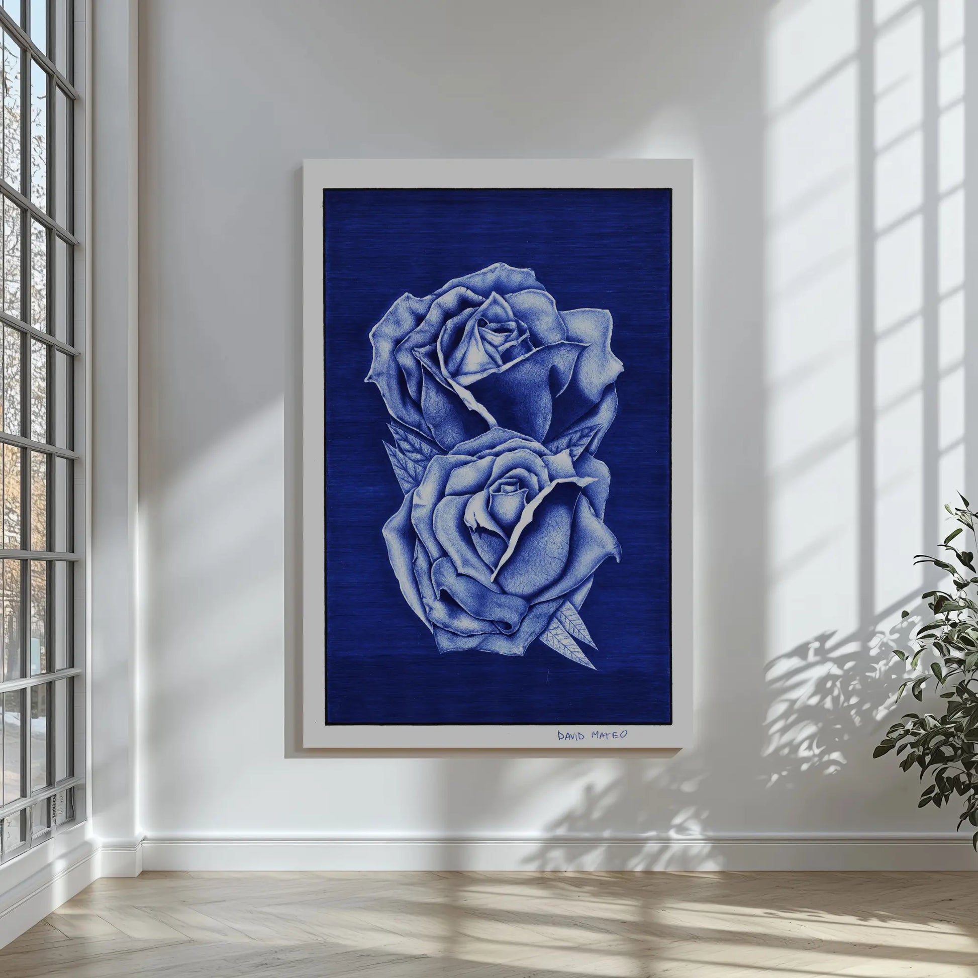 Lámina artística de dos rosas azules enmarcada junto a un sofá gris, mostrando la armonía decorativa de la obra.