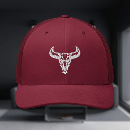 Gorra Trucker oscura con visera curvada y malla transpirable, con el logo del cráneo de toro bordado en blanco. Perfecta para un estilo urbano y alternativo.