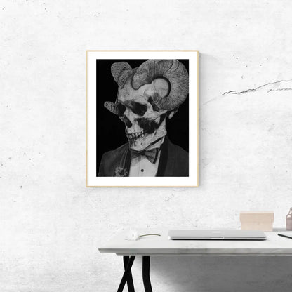 Lámina enmarcada en blanco sobre una estantería blanca. Muestra un dibujo monocromático de un cráneo con cuernos y vestido de traje, junto a un jarrón de planta.