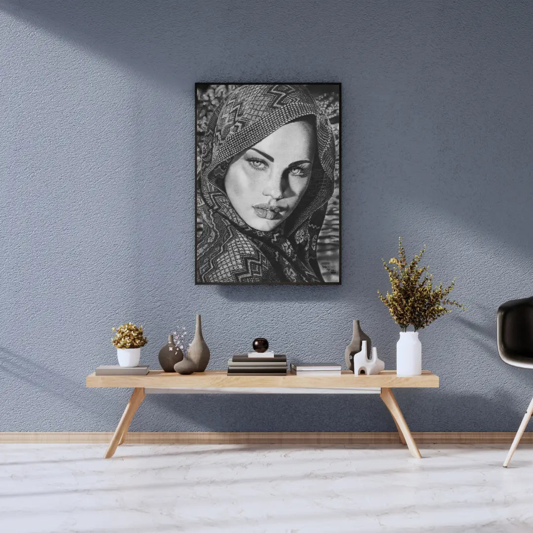 Foto de una lámina enmarcada de arte femenino monocromático colgada sobre una pared azul texturizada, en un salón de estilo escandinavo.