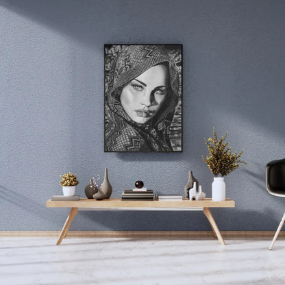 Foto de una lámina enmarcada de arte femenino monocromático colgada sobre una pared azul texturizada, en un salón de estilo escandinavo.