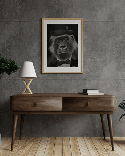 Print de arte gorila satírico '¡Qué Mono!' colgado en pared de concreto, destacando su estilo hiperrealista y crítica social en decoración contemporánea.