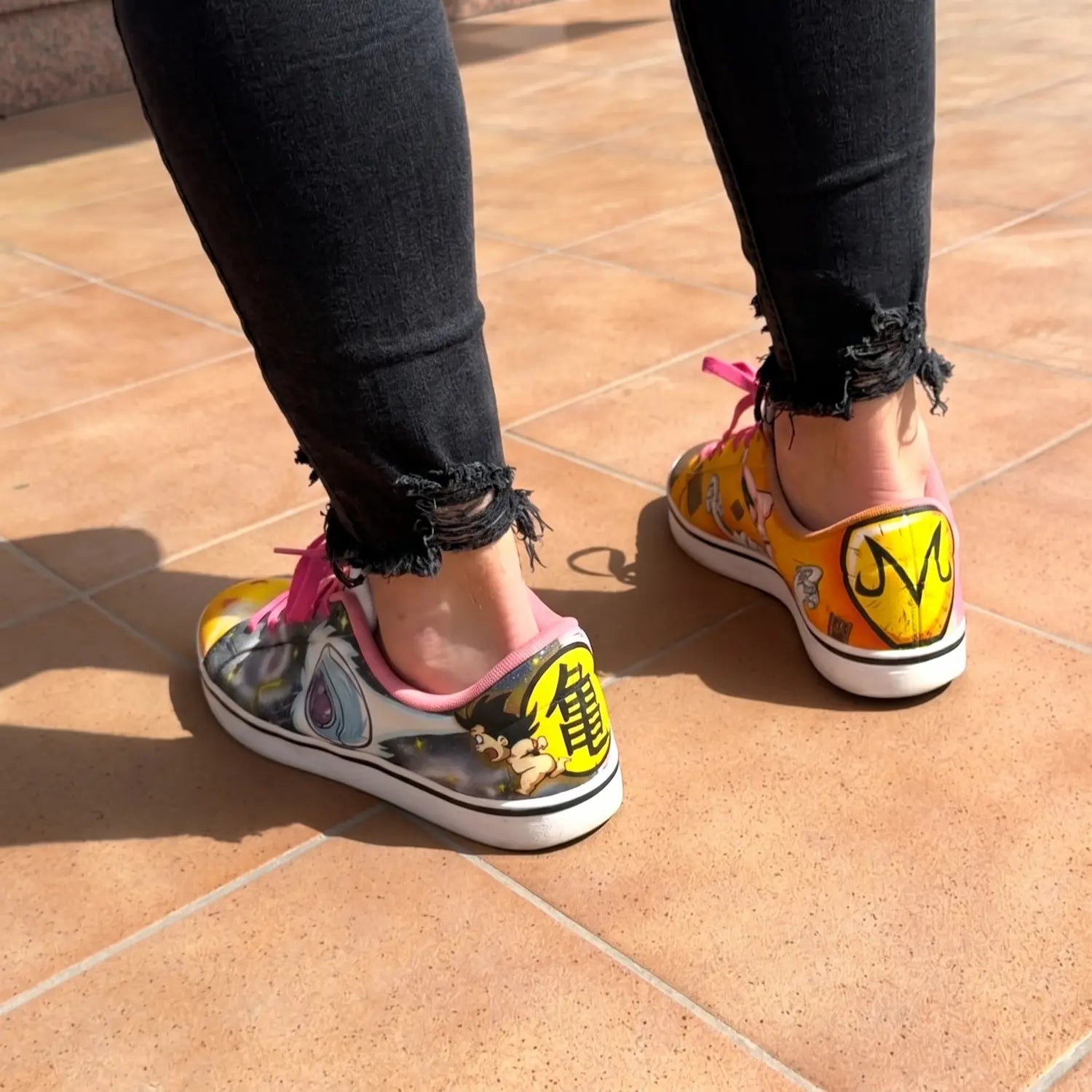 Zapatillas personalizadas a mano de Dragon Ball por el artista David Mateo luciéndolas con un pantalón vaquero negro.